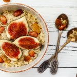 Amaranth und Quinoa-Brei-Frühstücksschüssel mit Feigen, karamellisierten Mandeln, Rosinen und Honig